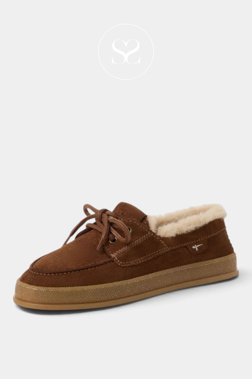 A single brown suede slip-on shoe with a cream shearling lining and a tan sole, shown on a light gray background with a faint brand logo above.