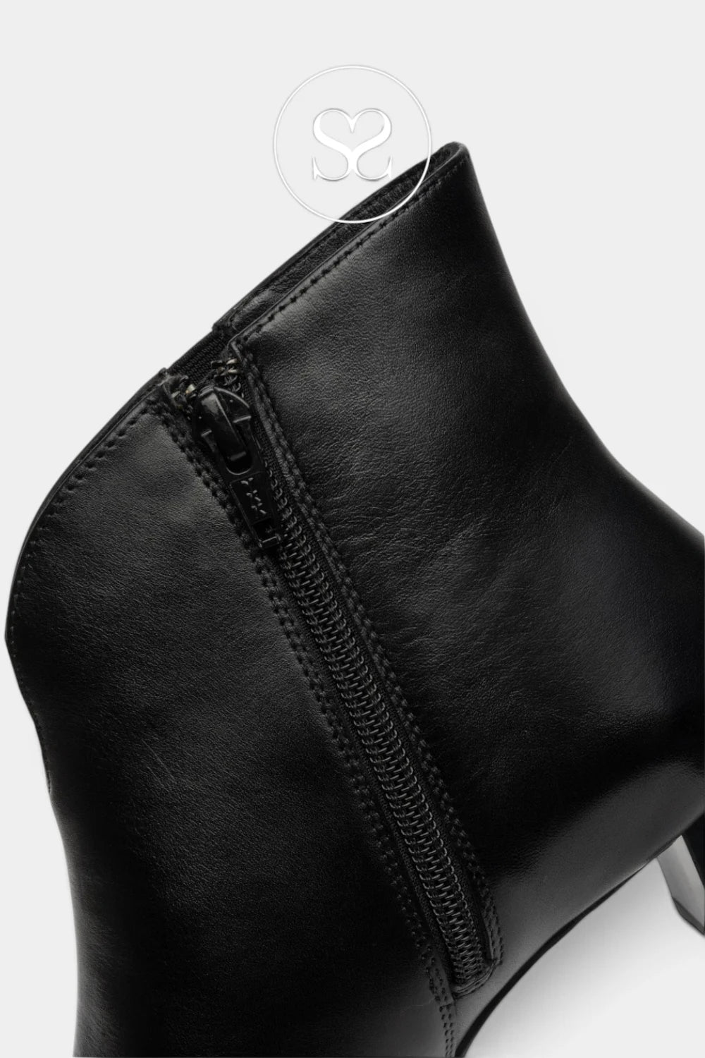 Close-up of a black leather ankle boot showing the side zipper, stitching, and part of the heel on a light gray background.