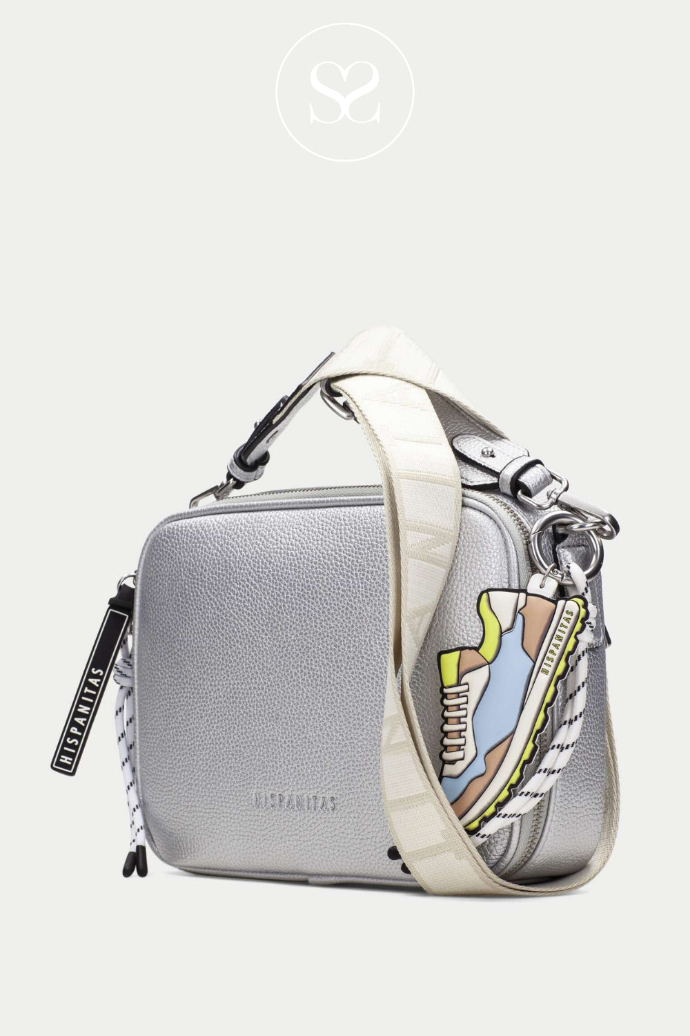 Hispanitas spanish crossbody bag. Metallic silver handbag with wide logo strap and zip pocket. Trainer keyring