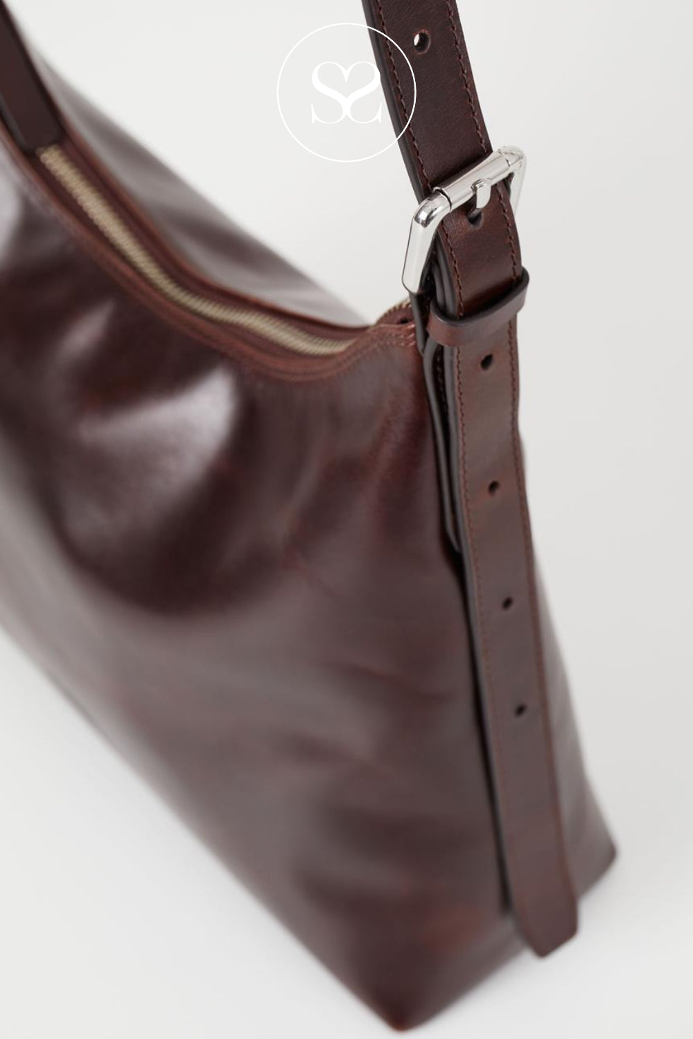 Brown leather handbag with an adjustable strap and a zip closure