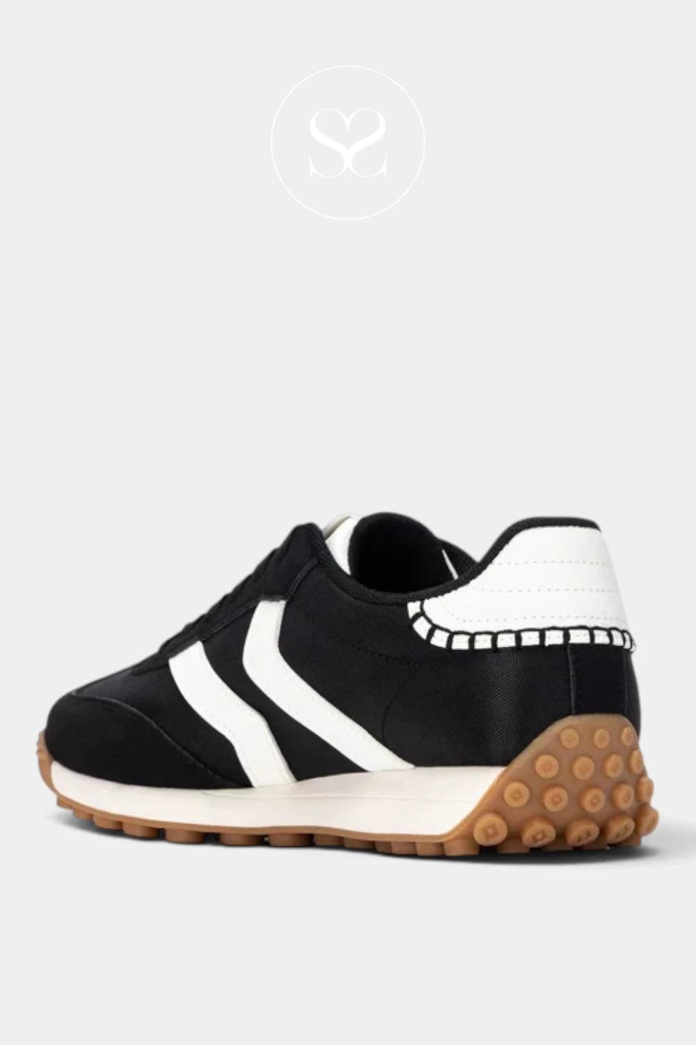 A black and white low-top sneaker with a distinctive brown textured rubber sole, shown from a side profile view on a light gray background.