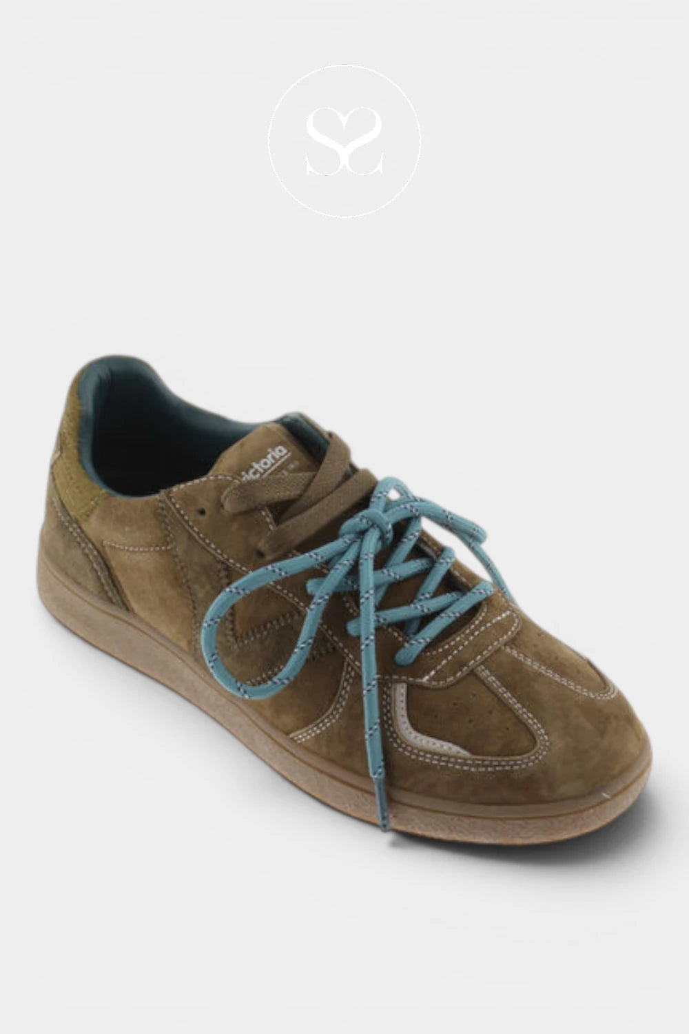 A low-top brown suede sneaker with contrasting blue-green laces, a tan sole, and a dark interior lining, shown on a light gray background with a faint logo watermark above.