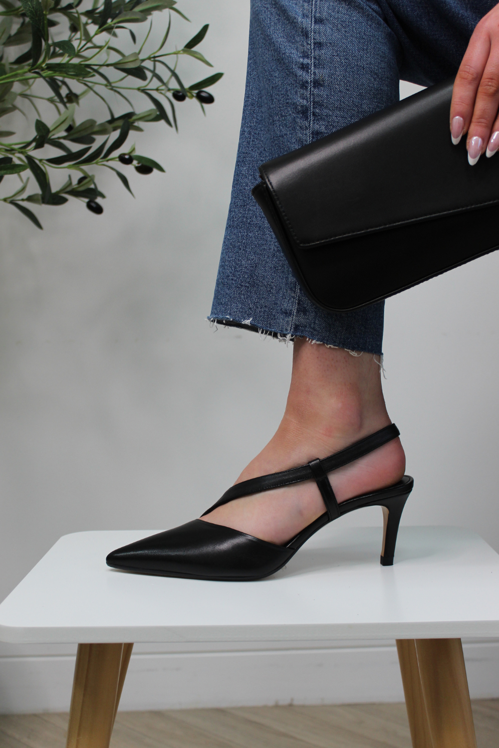 Lodi black leather pointed toe assymetrical heels. Mid height heel, strap across foot and gel cushioning.