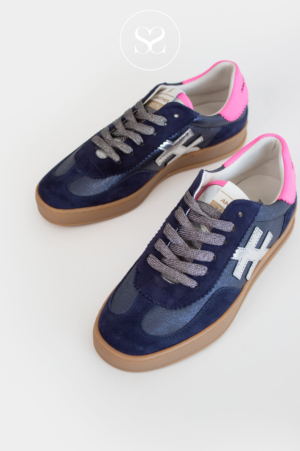 Pair of navy blue sneakers with pink accents on a white background