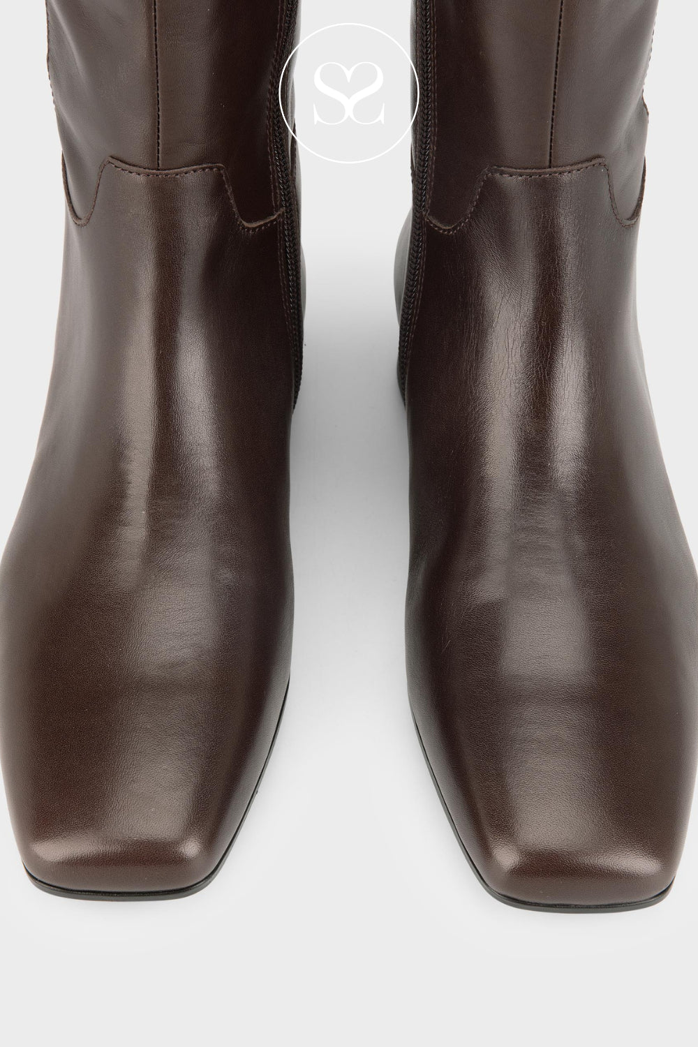 A pair of dark brown leather knee high boots with square toes, shown from a front-facing perspective on a light gray background.