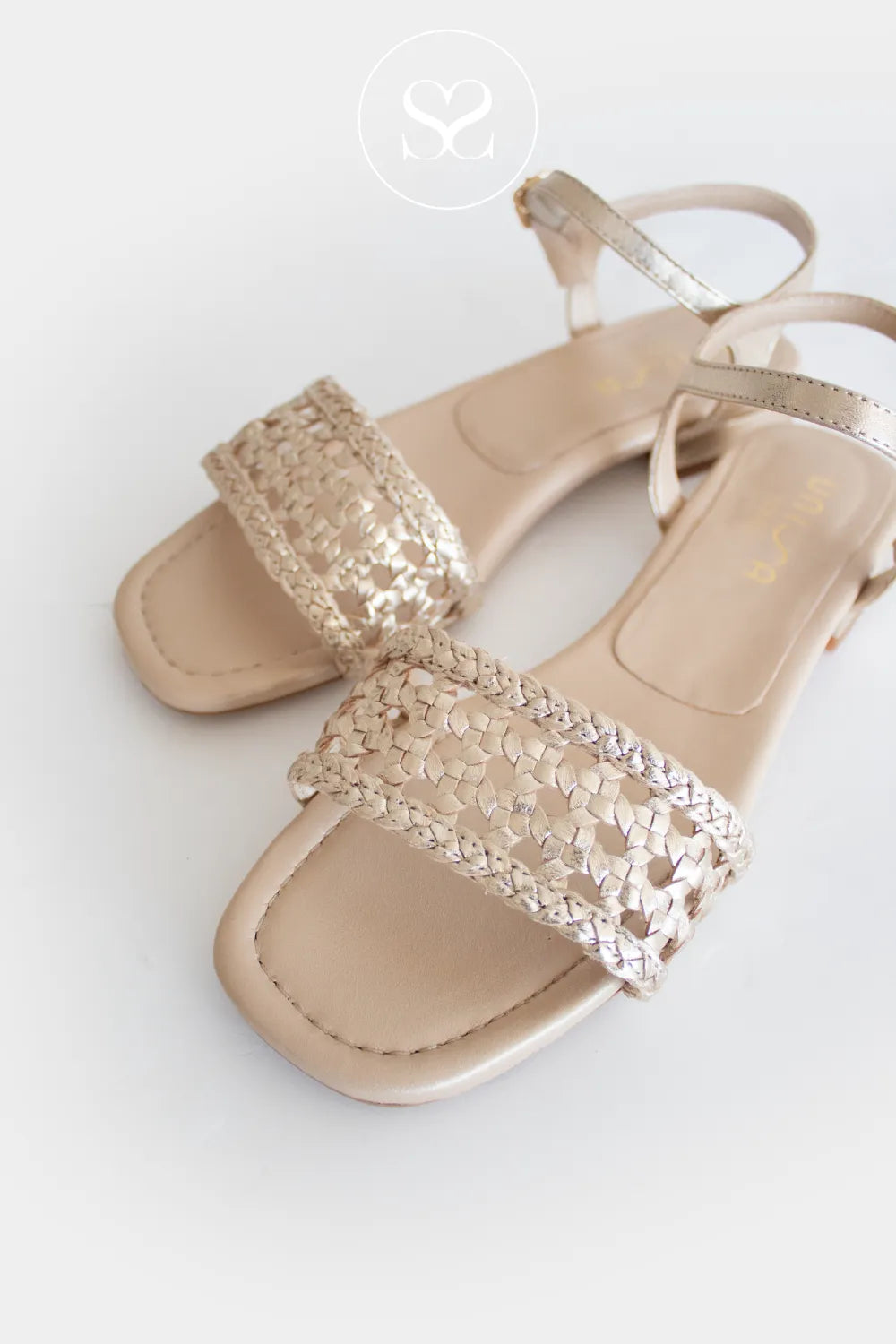 Unisa Calaf gold braided minimal summer sandals. Flat sandal with adjustable ankle strap and woven front strap.