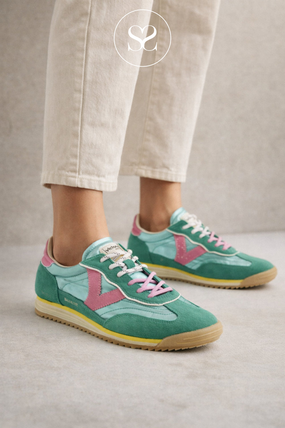 Woman wearing green metallic trainers from Victoria with slight wege sole