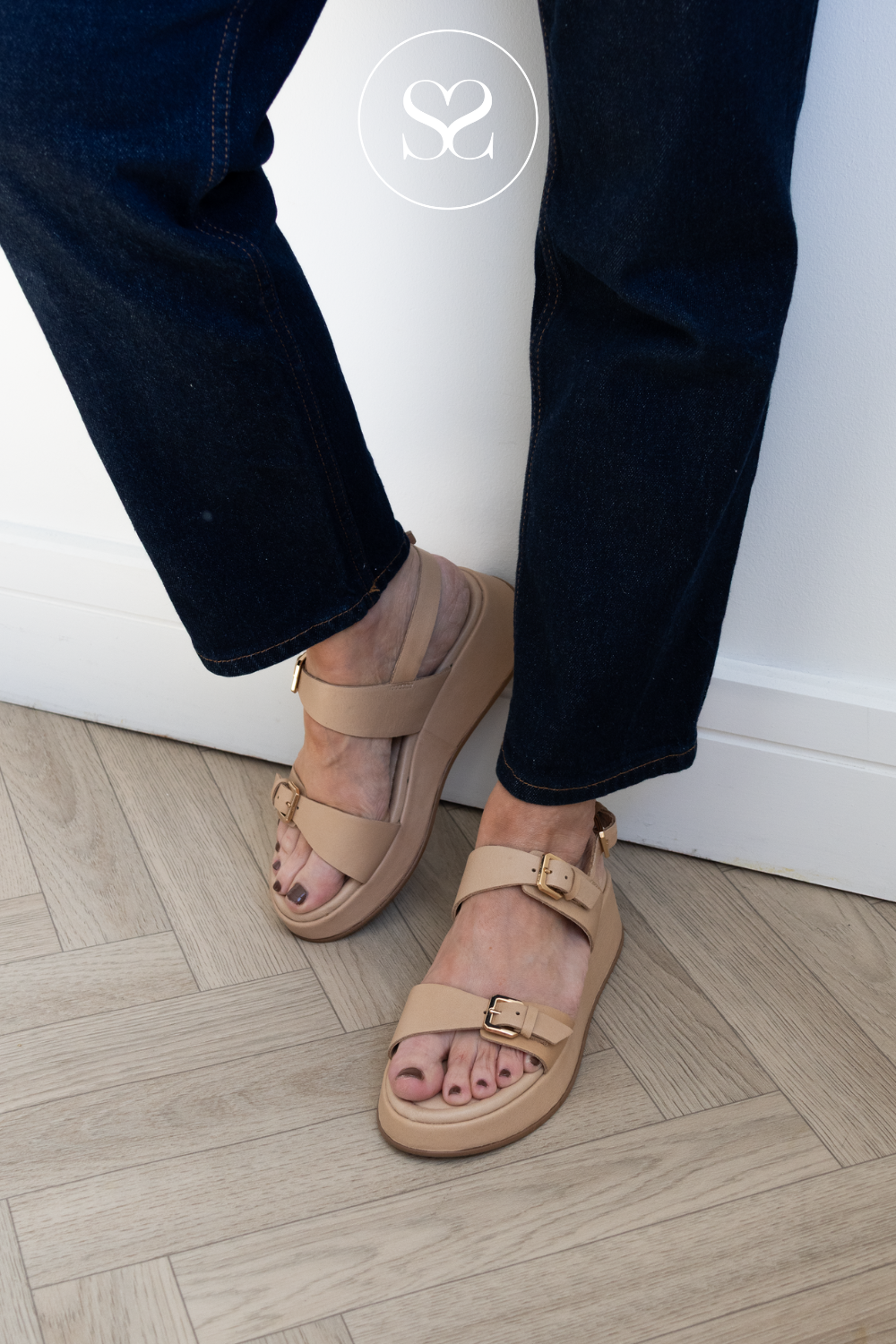 Woman wearing camel flatform sandals from Wonders with adjustable straps and gold buckles