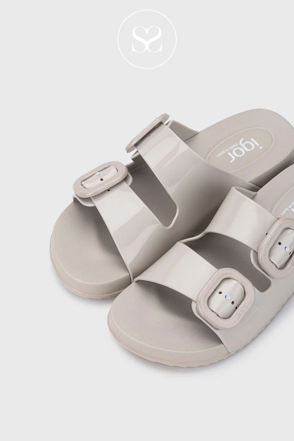 Pair of beige slider sandals with buckle straps on a light gray background from Igor - available in Ireland