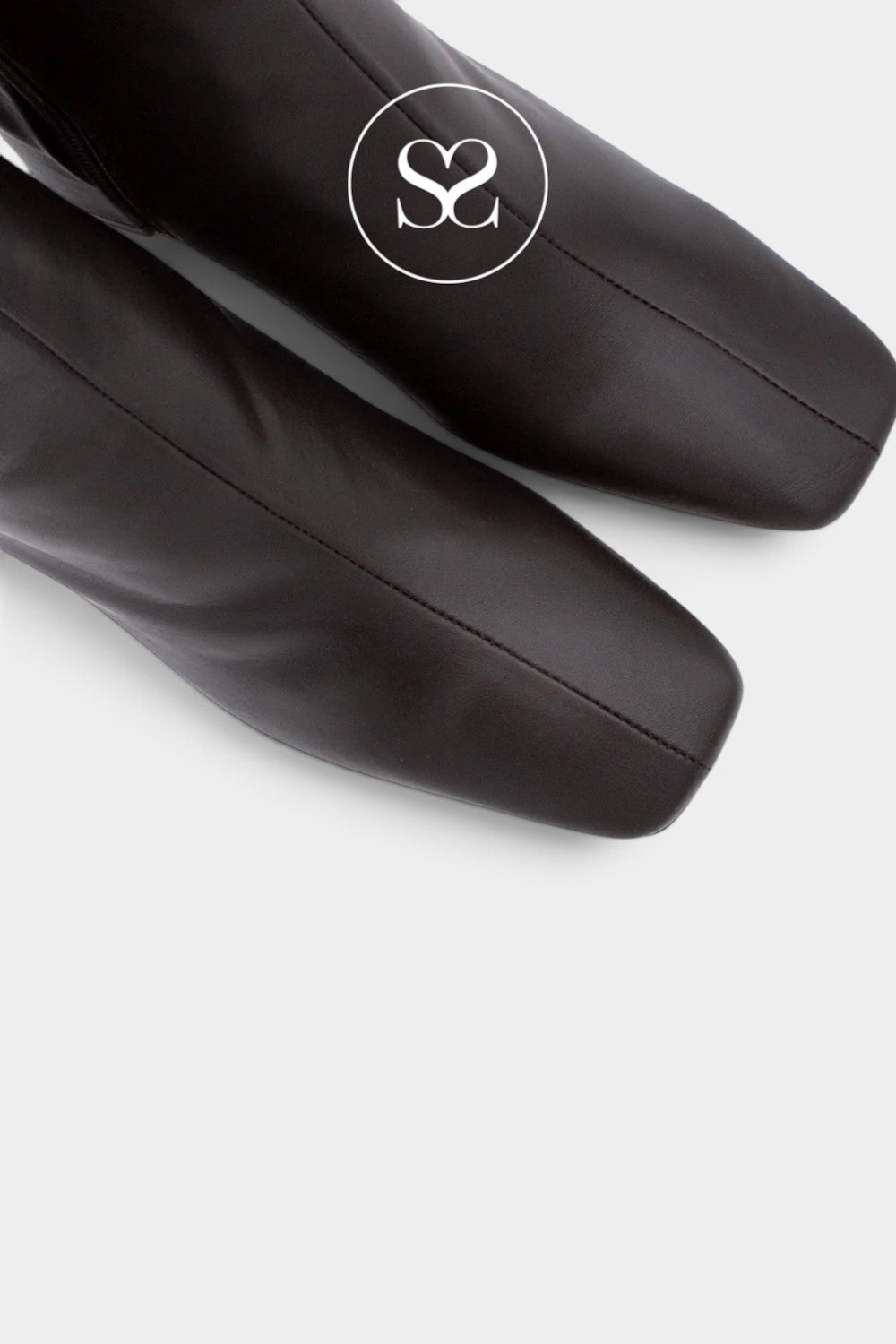 Close-up of a black leather boot with a square toe and a white circular logo overlay featuring the letters 'S2'.
