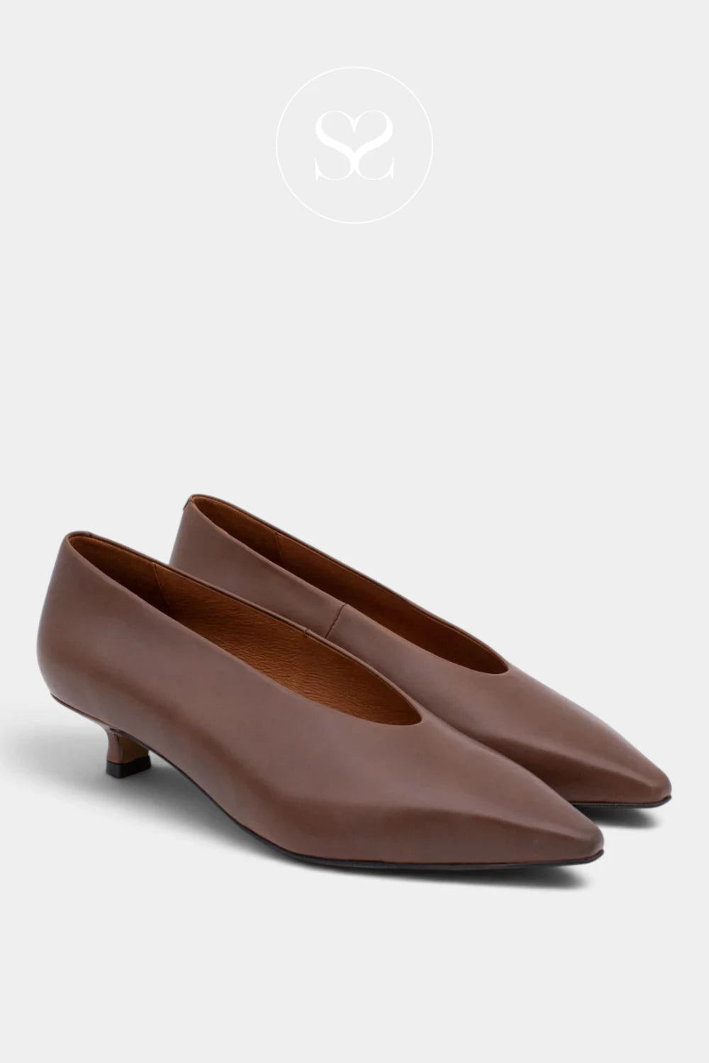 A pair of women's pointed-toe flats in smooth brown leather with low kitten heels, shown on a light gray background with a faint brand logo at the top.