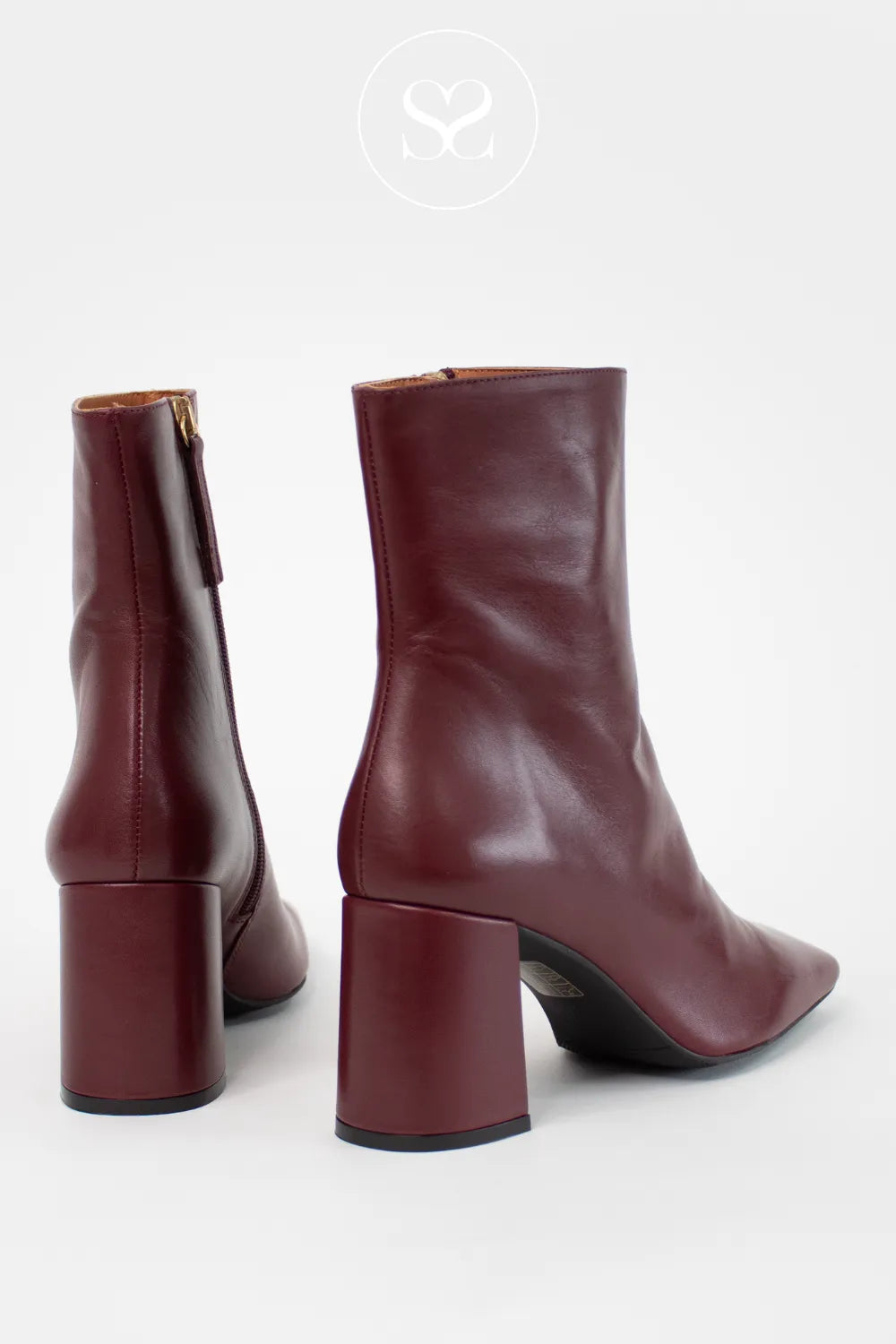 Pair of maroon ankle boots with block heels on a white background