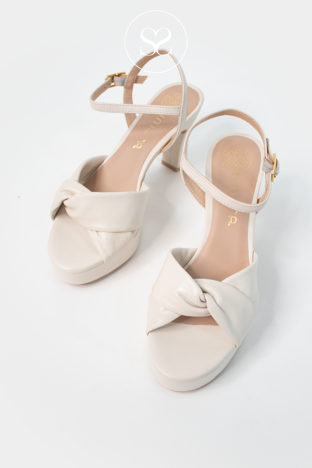 Unisa Onoa cream leather platform block heels with adjustable ankle strap and knotted criss cross strap across the foot. Occassionwear heels