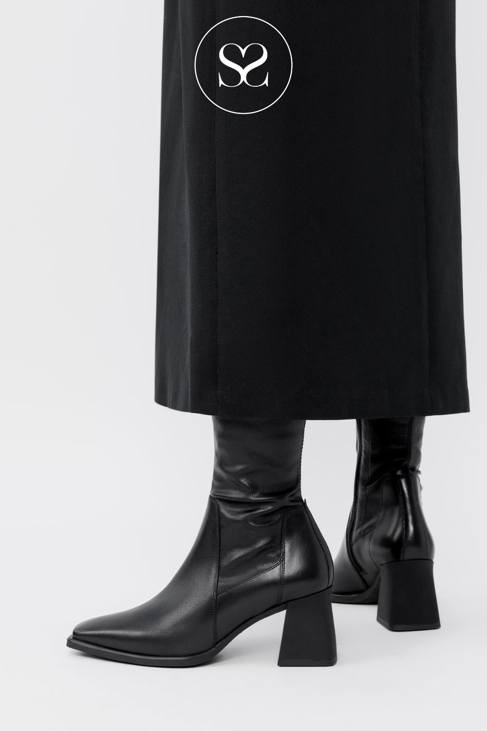 Woman wearing black leather sock boots with square toe and block heel from Vagabond Shoemakers in Ireland