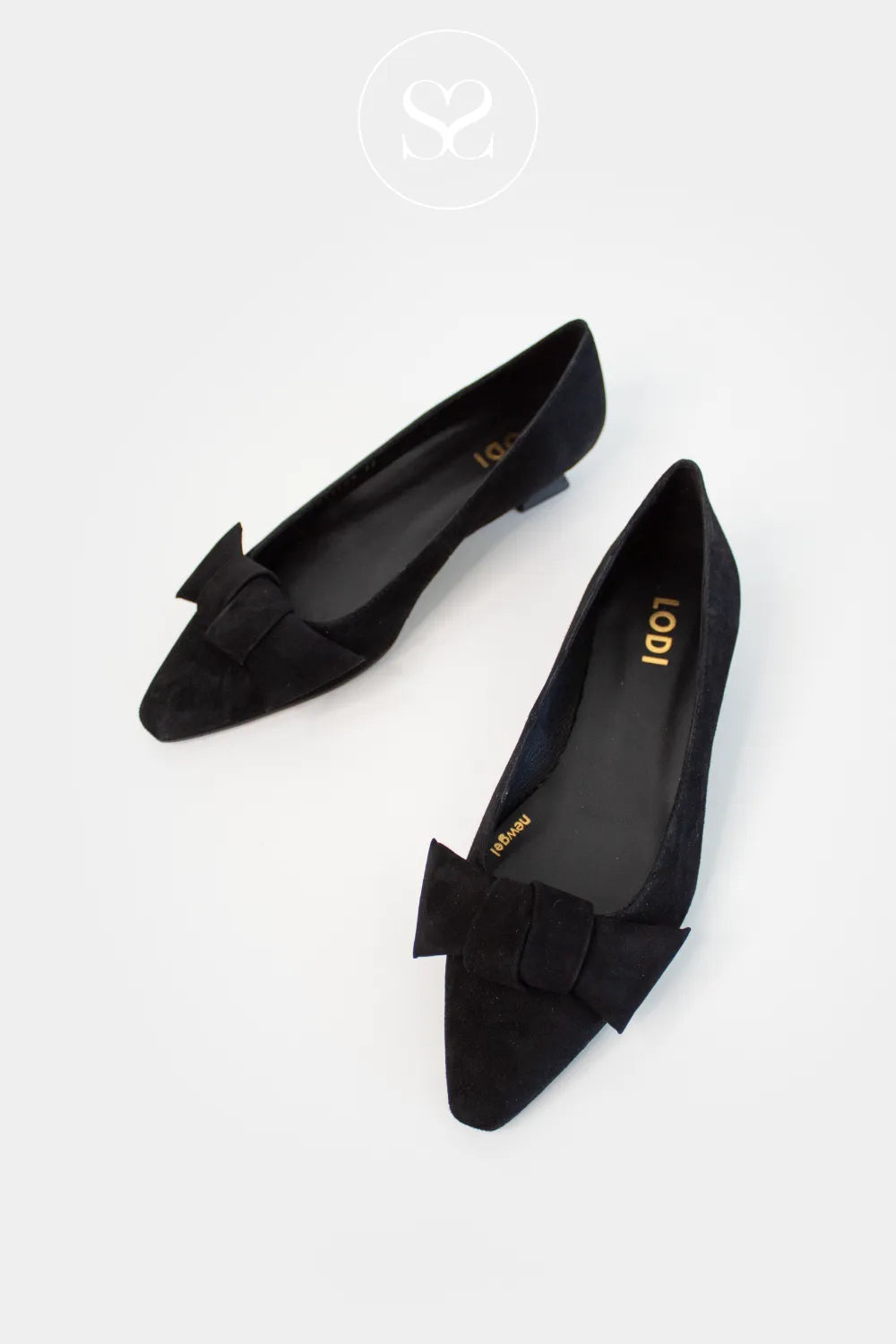 Black pointed-toe flats with bow details on a white background