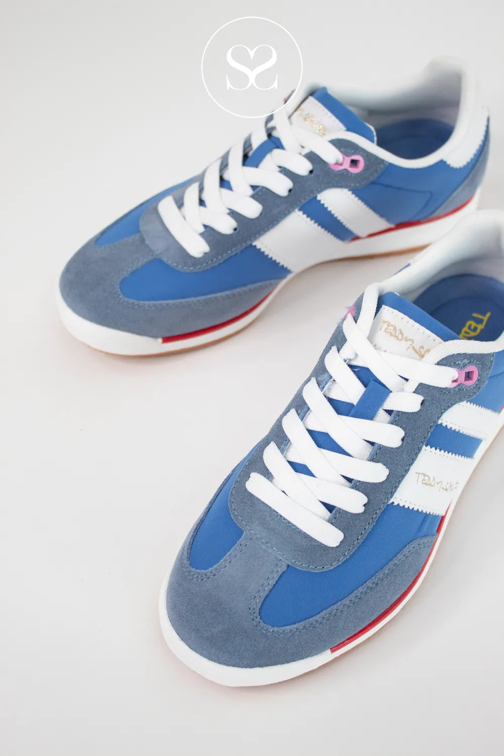 Blue and gray sneakers with white laces on a light background