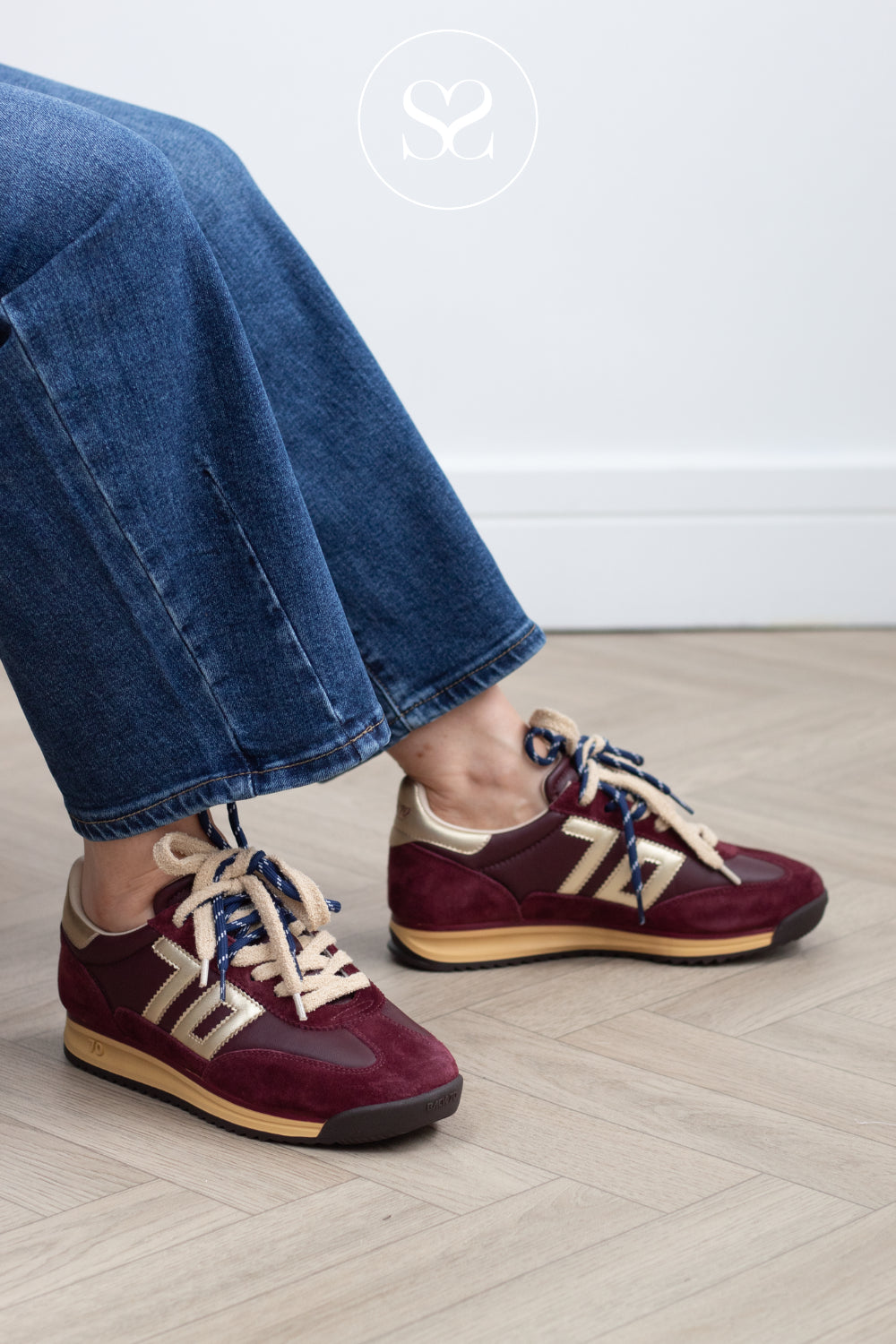 woman wearing comfortable burgundy / wine sneakers from Back 70 with gold details and double lace feature