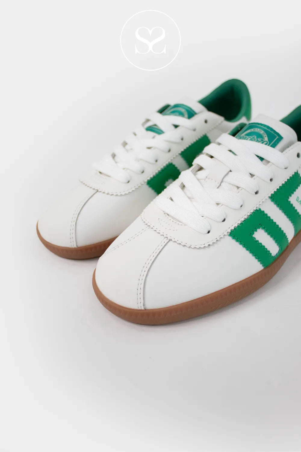White retro style leather trainers with green logo, laces and gum sole.