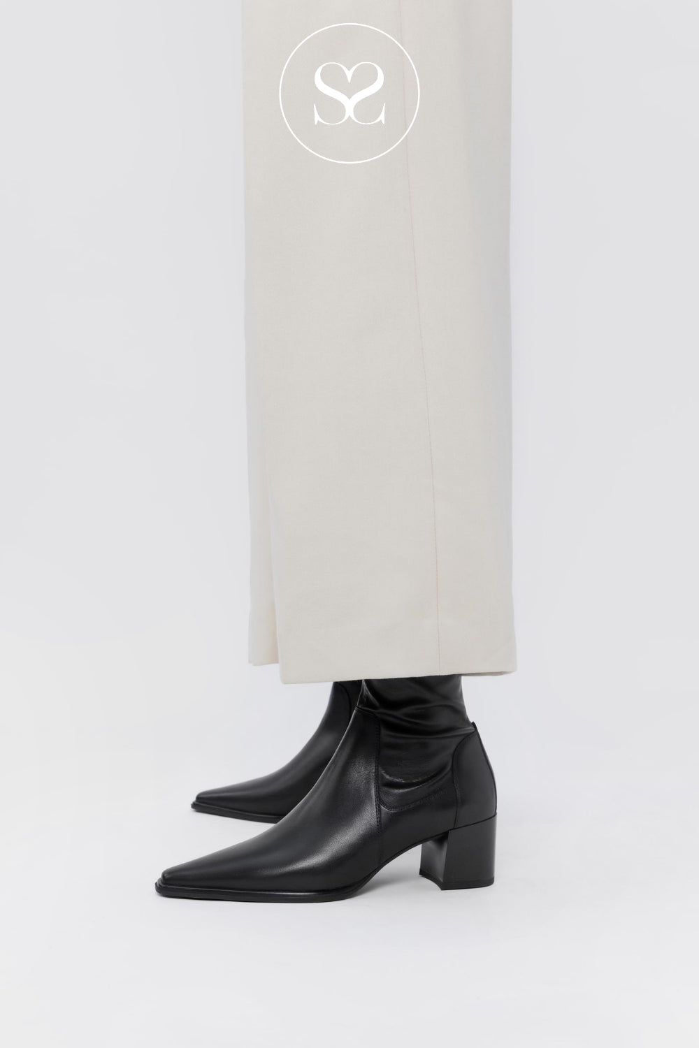 A stylish woman's outfit featuring Vagabond Giselle sock boots, paired with White trousers