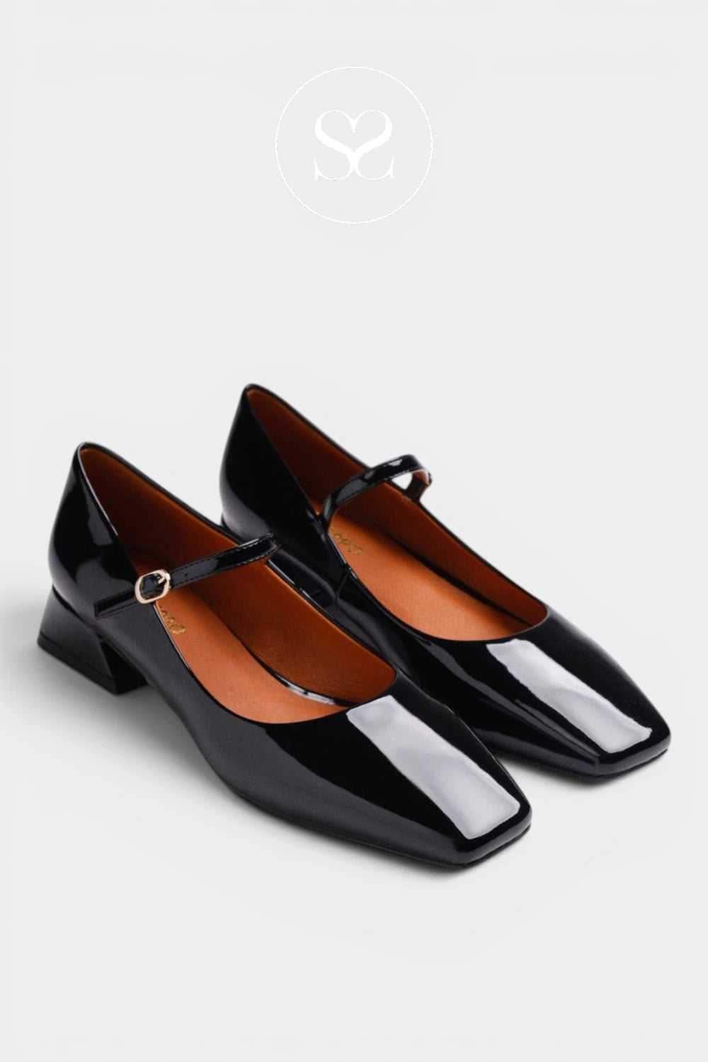 A pair of black patent leather Mary Jane shoes with low block heels and square toes, displayed on a light gray background with a faint circular logo above them.