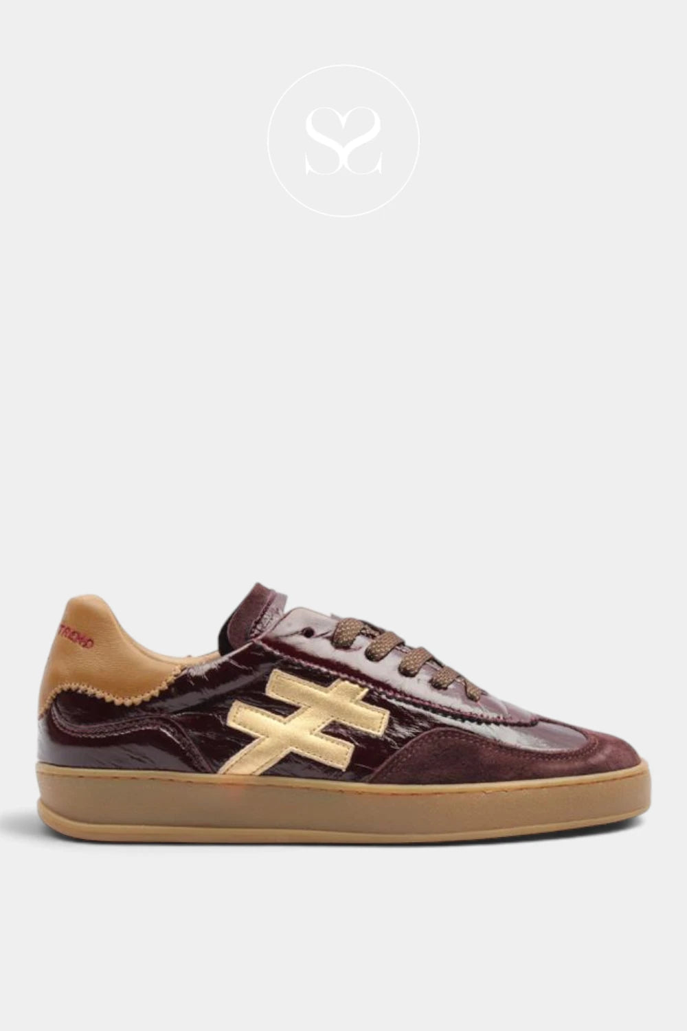 An Another Trend low-top sneaker in dark burgundy patent leather and suede with a tan suede collar, brown laces, and a gold-toned geometric side logo, set against a light gray background.