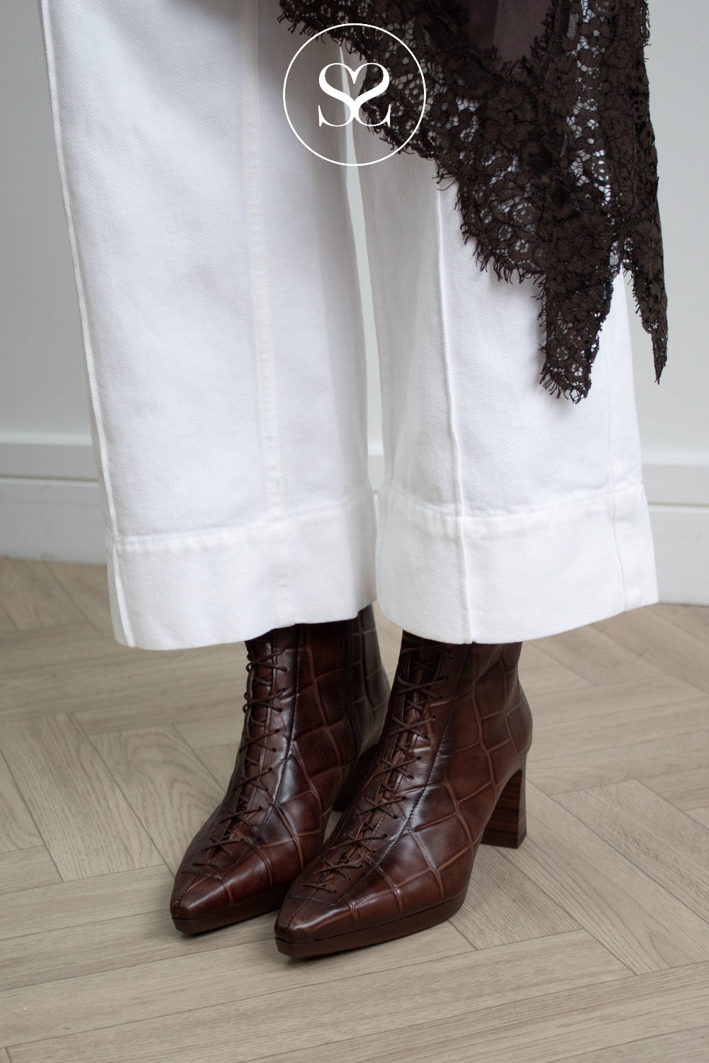 woman wearing textured chocolate brown leather ankle boots with ointed toe, lace up front and block heel from Hispanitas
