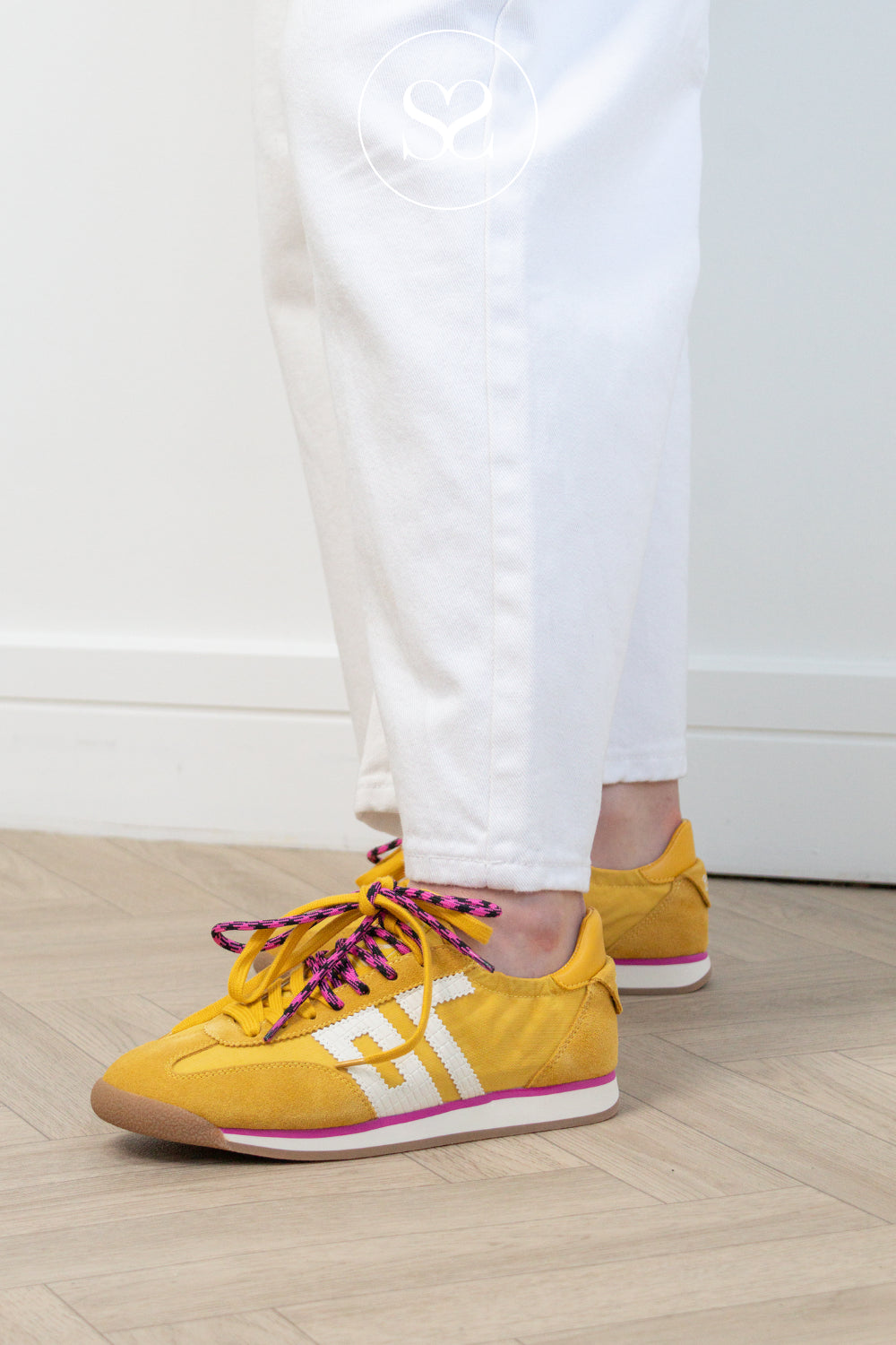 Woman wearing yellow back 70 sneakers with double lace and slim retro design