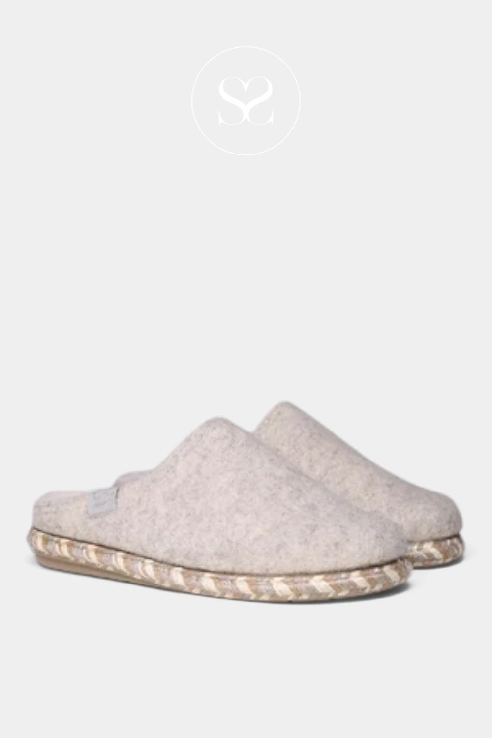 A pair of light beige felt slip-on slippers with braided jute soles, shown against a light gray background with a faint brand logo above.