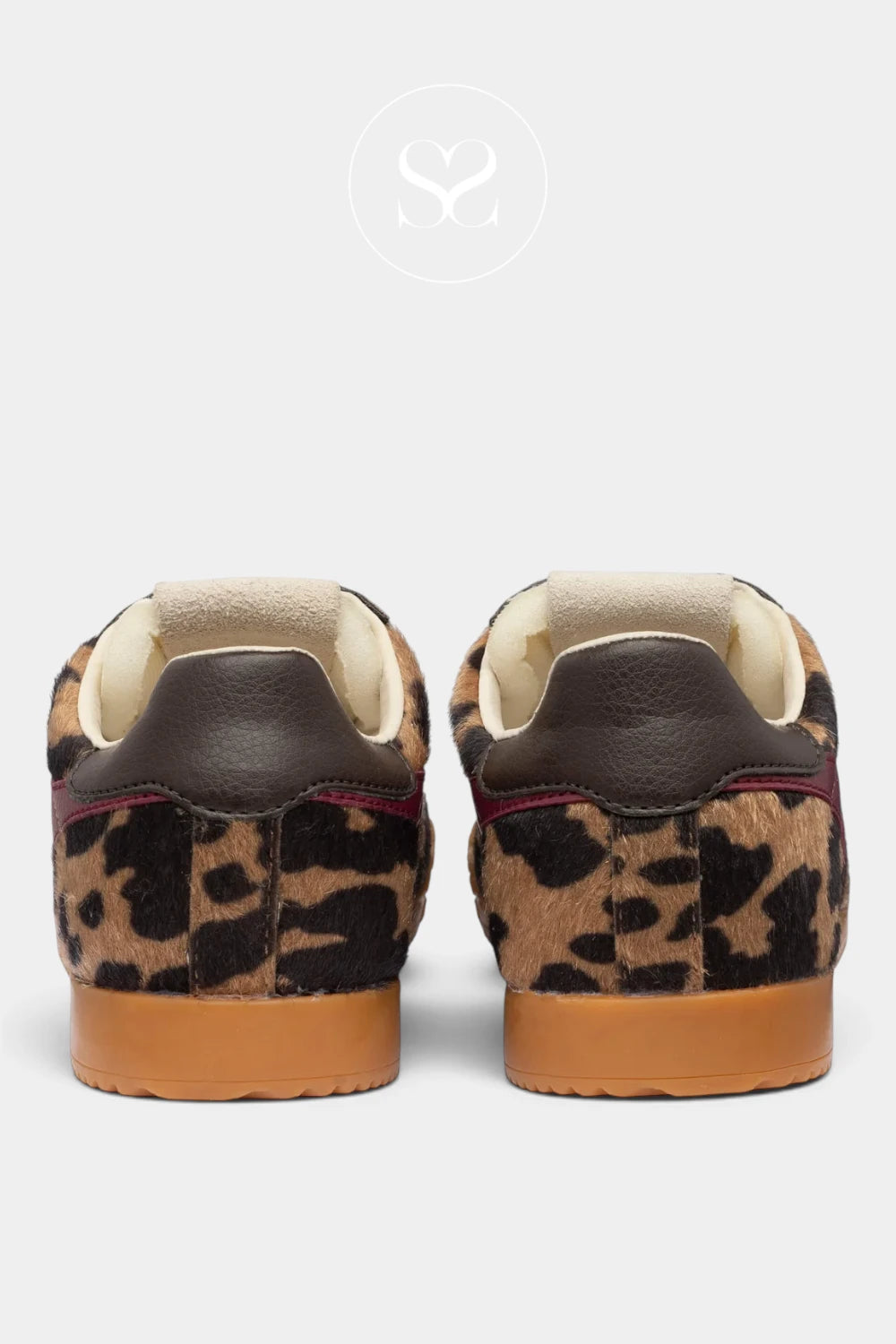 A pair of low-top sneakers shown from the back, featuring a brown and black leopard print upper, dark brown leather heel tabs, cream-colored lining, and tan rubber soles, set against a light gray background.