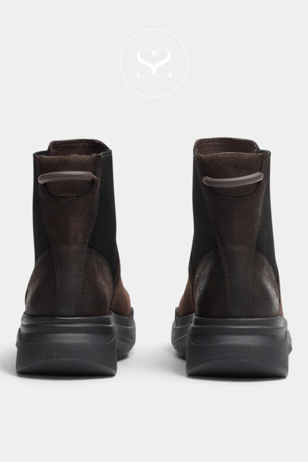 A pair of dark brown and black ankle boots shown from the back, featuring a chunky black sole and a circular logo watermark above on a light gray background.