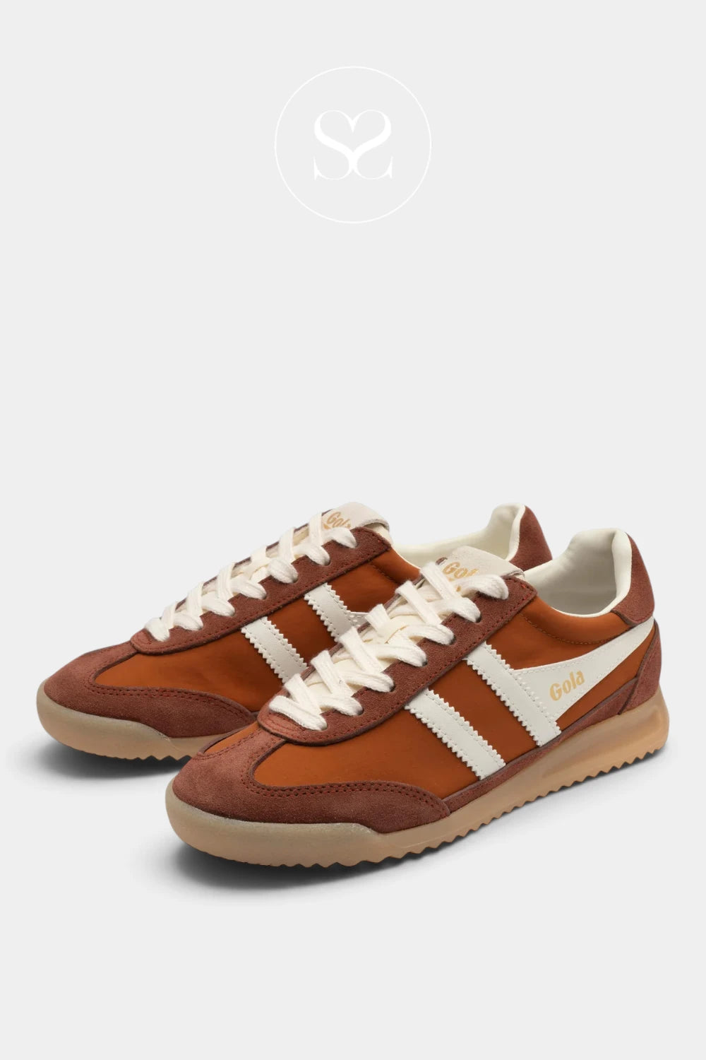 A pair of retro-style low-top sneakers in brown suede and orange-brown synthetic panels, with off-white laces, off-white side stripes, and a tan gum sole, shown on a light gray background.
