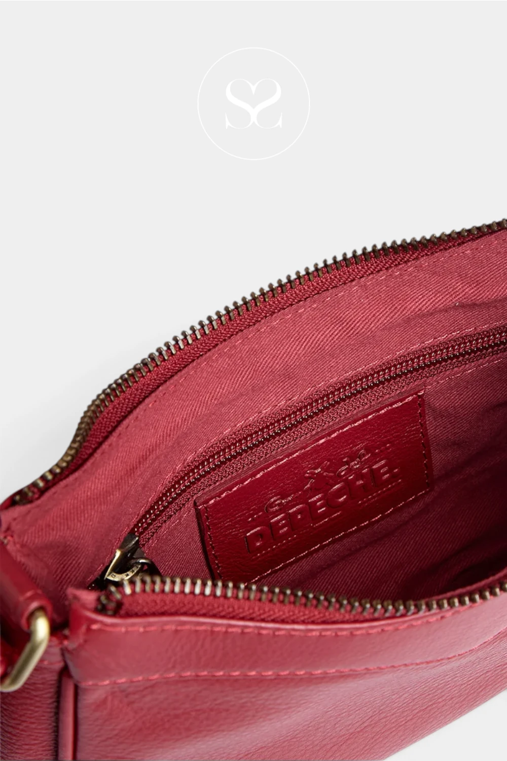 Close-up of a burgundy leather handbag interior showing a zippered compartment with a matching burgundy leather brand patch embossed with the Céréclier logo.