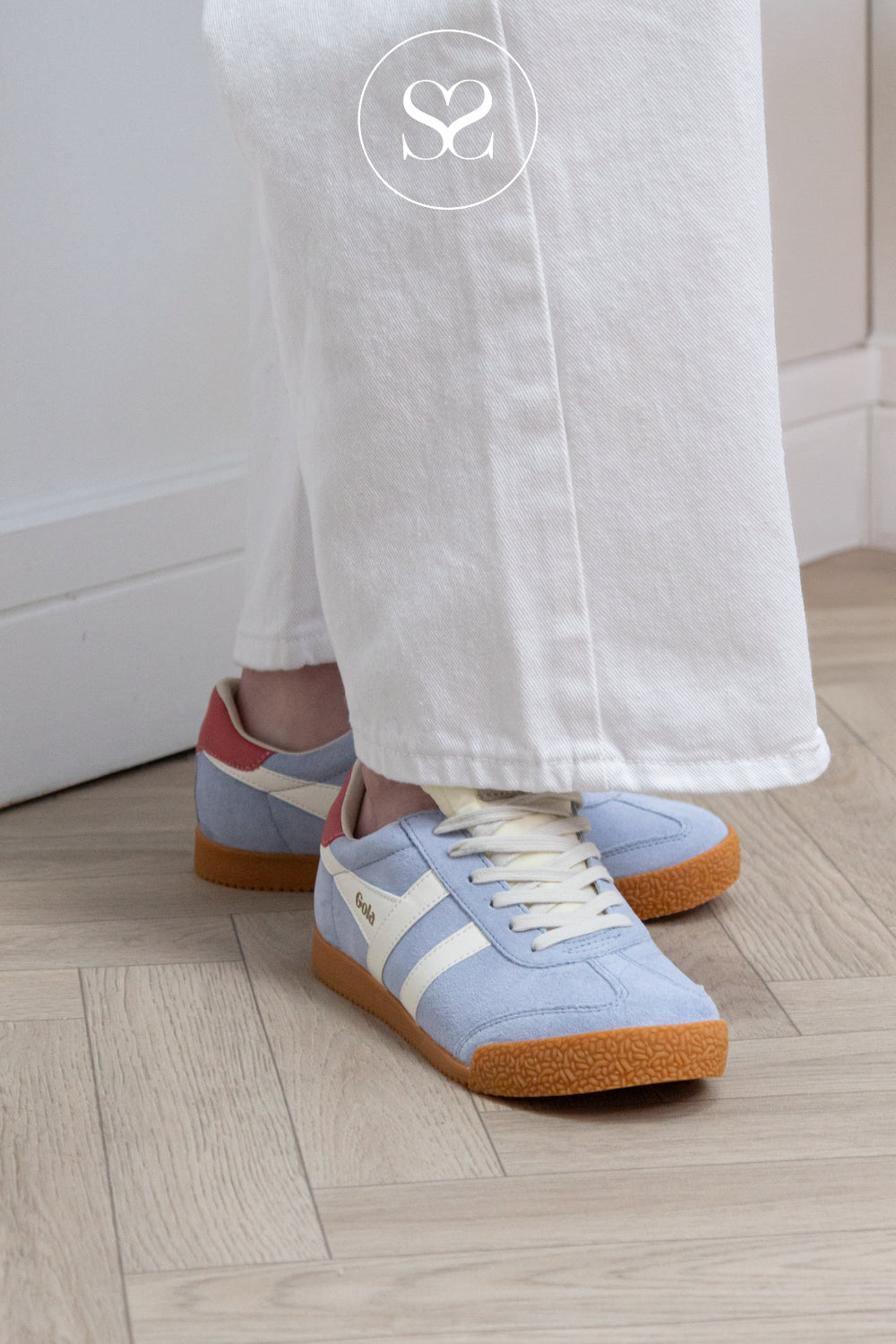 woman wearing pastel blue trainers from gola with white laces gum sole and pink heel cap