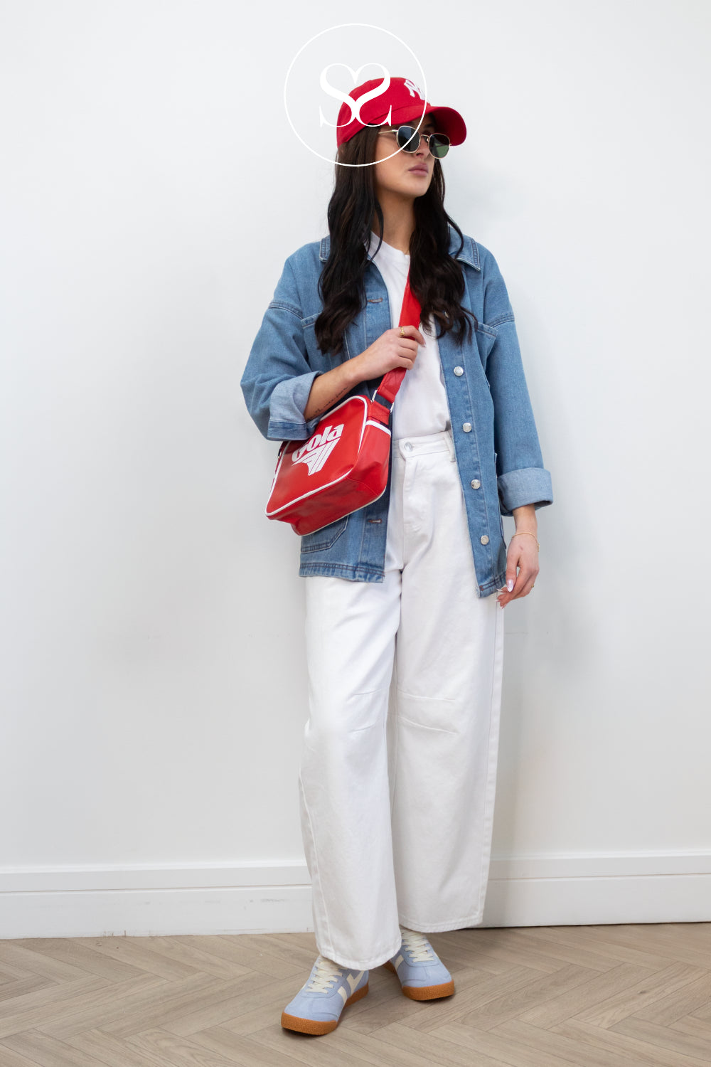 woman wearing red gola bag and blue gola trainers in studio in Ireland