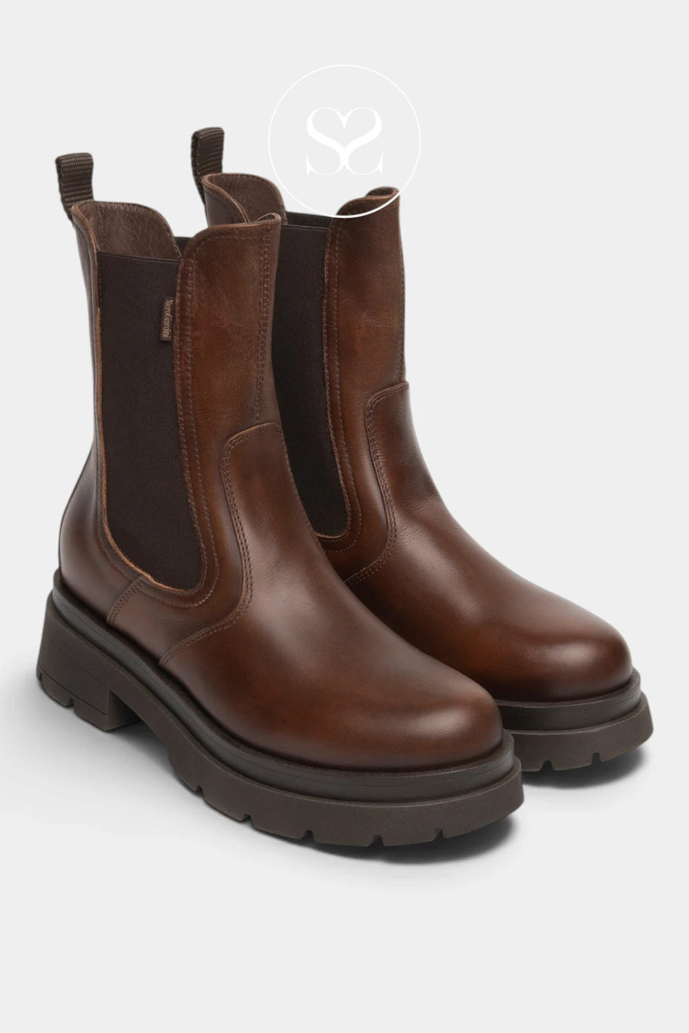 A pair of brown leather Chelsea boots with dark brown elastic side panels and chunky dark soles, shown on a light gray background.