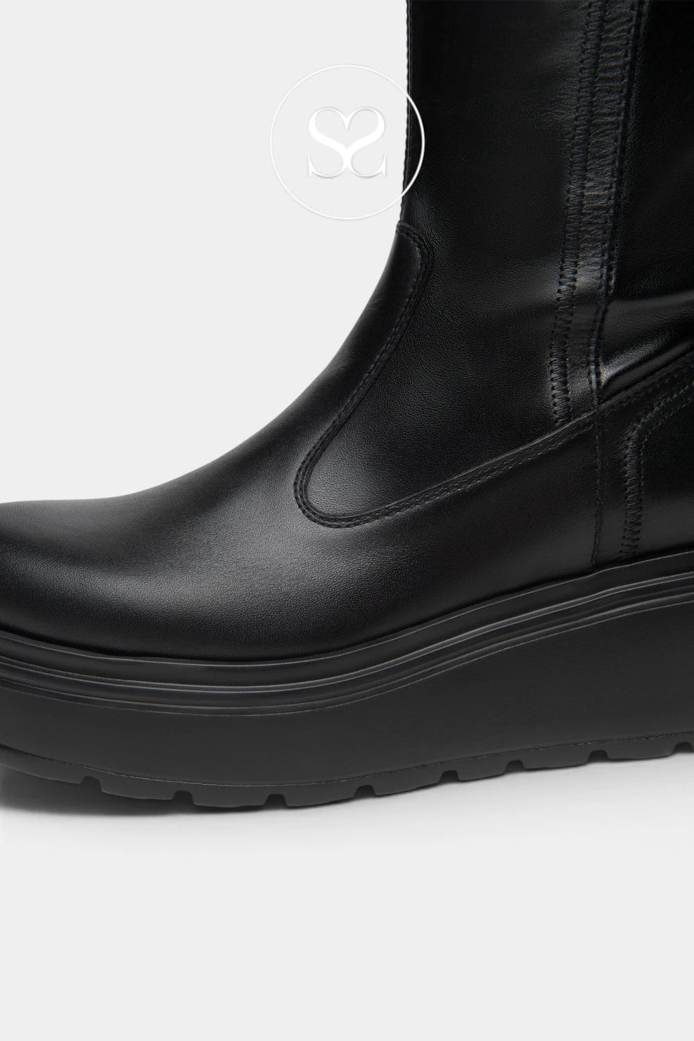 A close-up side view of a black leather ankle boot with a chunky platform sole, shown against a light gray background.