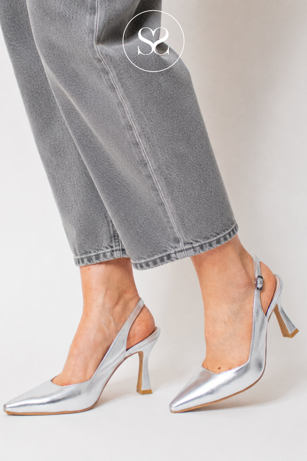 woman wearing sliver high heels with pointed toe and slingback design with flared heel - Lodi Modern