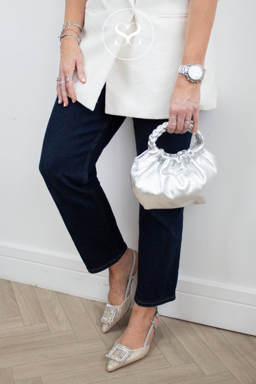 Woman wearing silver woven textured kitten heels from lodi and unisa silver bag