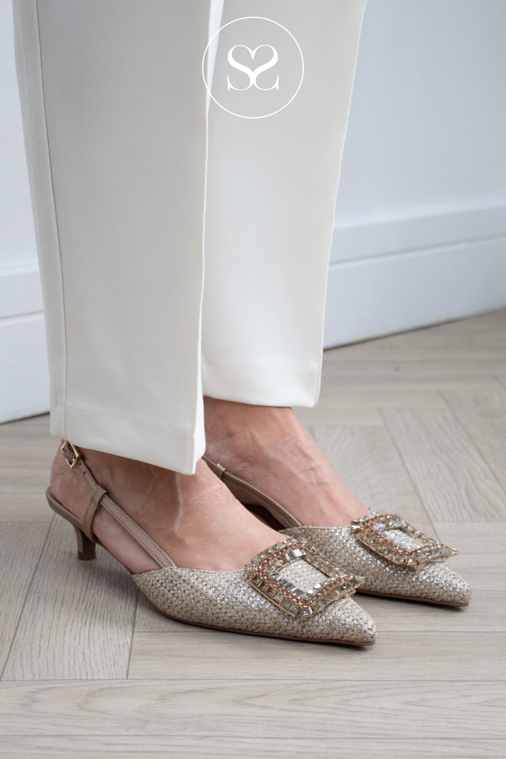 woman wearing natural woven slingback kitten heels from lodi with cream trousers