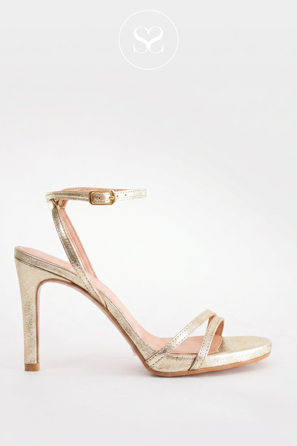 A single metallic gold strappy sandal with a high stiletto heel and ankle strap, shown from a side profile on a light grey background. Available in Sheneil Shoes Ireland