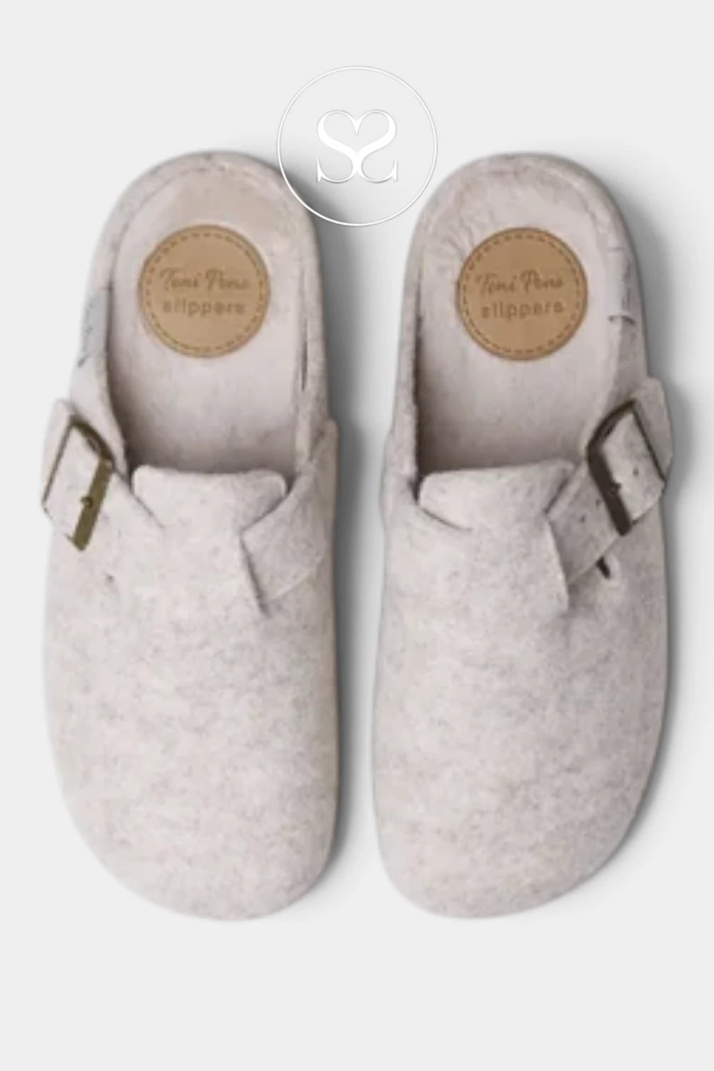 A pair of light beige felt slip-on clogs with adjustable brown leather straps and circular tan brand patches on the footbeds, shown from a top-down view on a light gray background.
