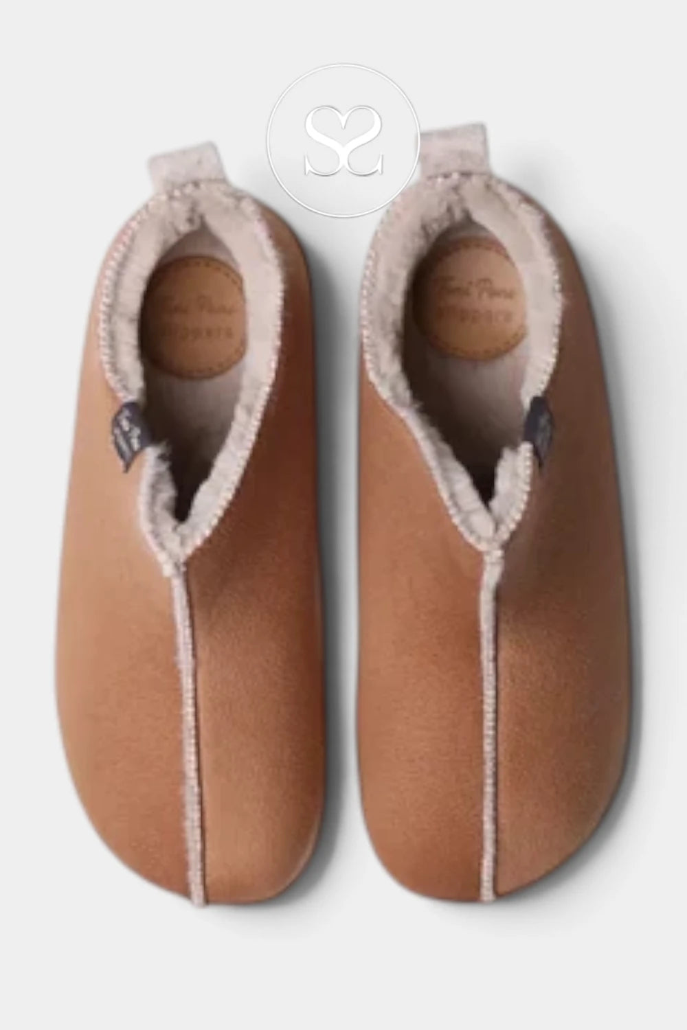 A pair of tan suede slip-on slippers with a soft cream sherpa lining, shown from a top-down view on a light gray background.