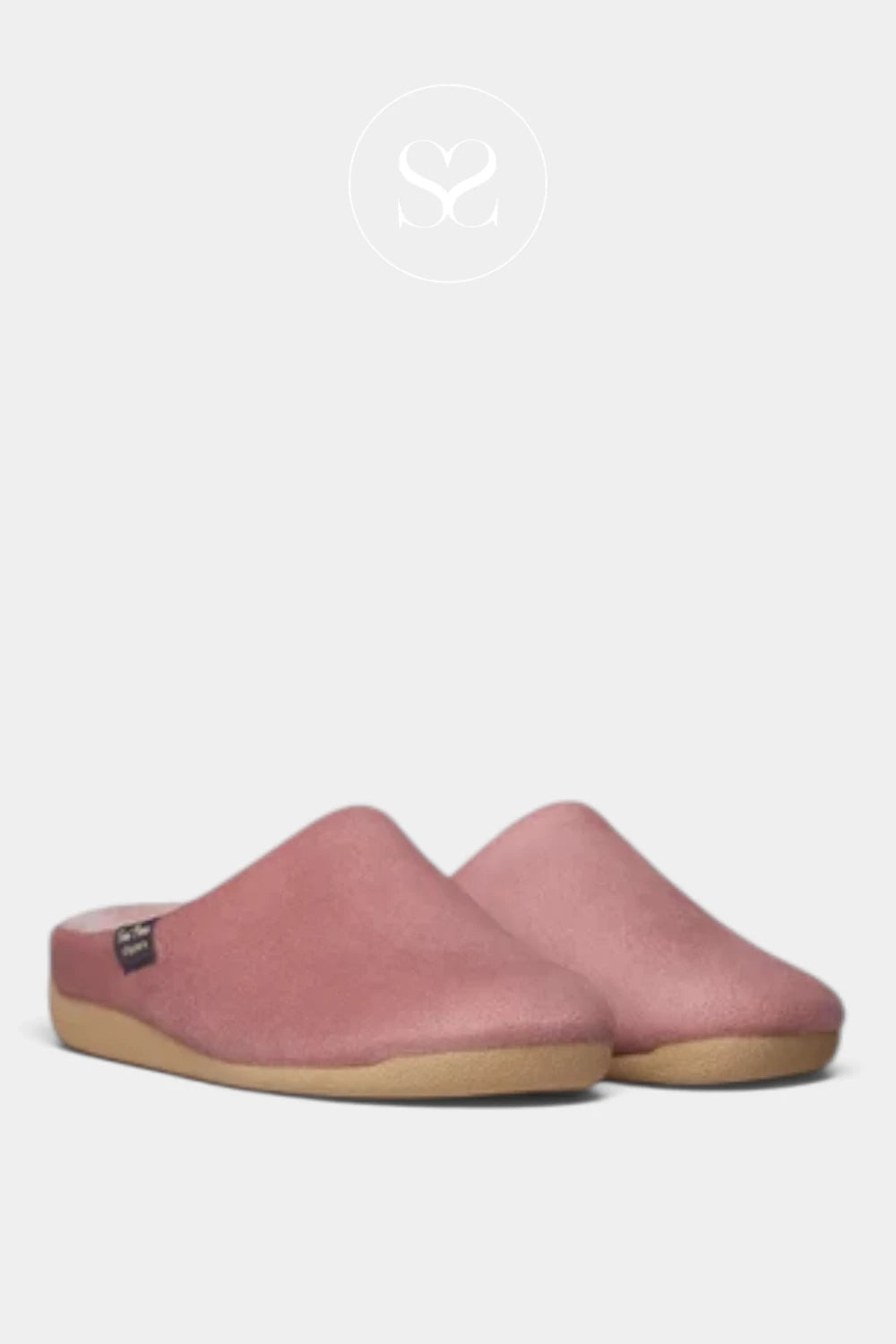 A pair of dusty pink slip-on slippers with a natural tan rubber sole, shown against a light gray background with a faint brand logo at the top.