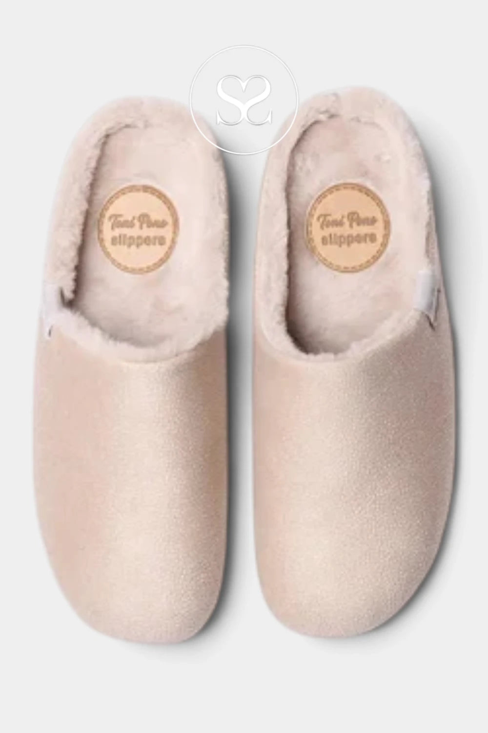 A pair of light beige slip-on slippers with soft pink faux fur lining, shown from a top-down view on a light gray background. A circular brand logo for 'Tote Pouch slippers' is visible on the insole of each slipper.