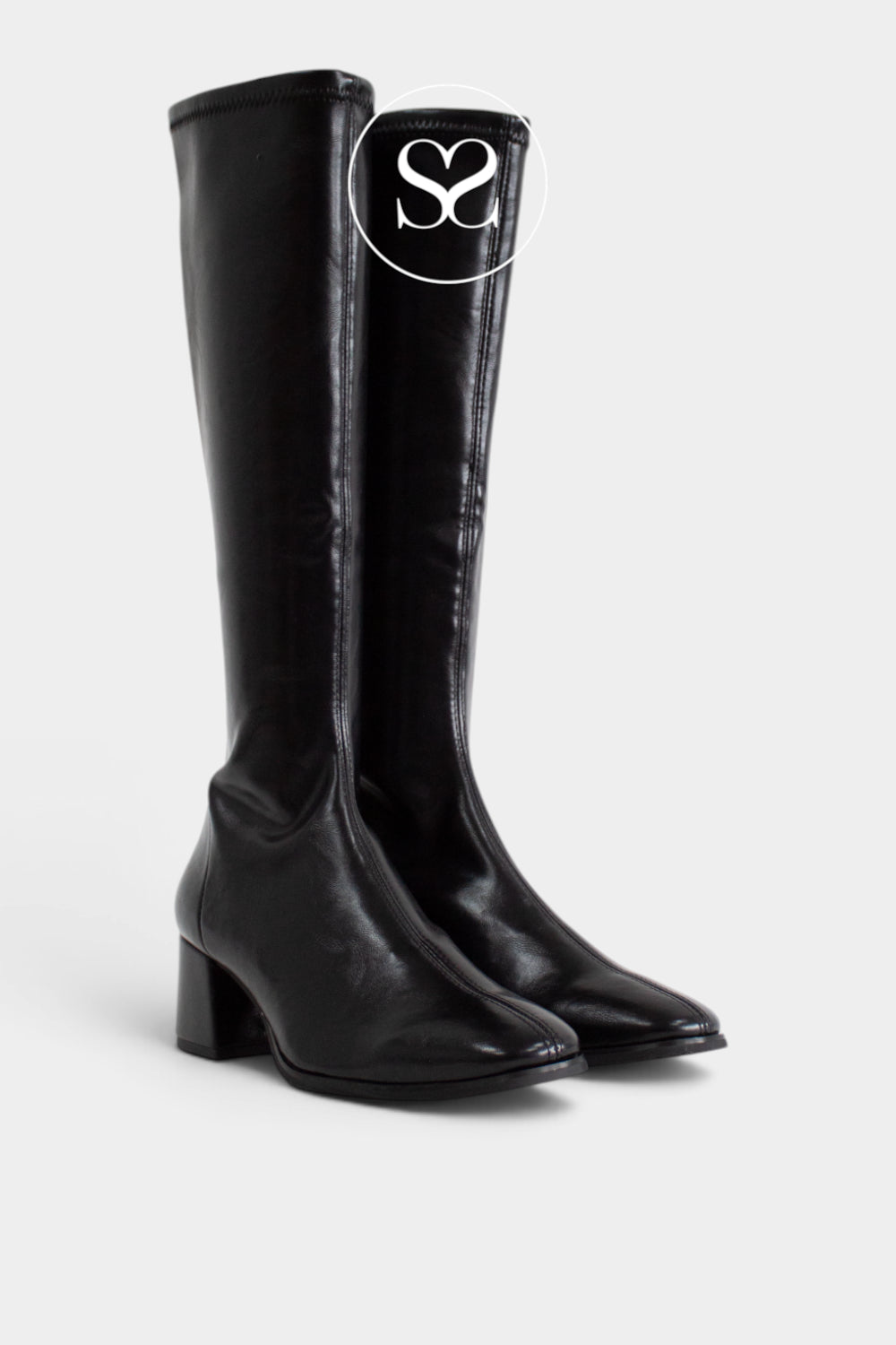 A pair of black leather look knee-high boots with a low block heel and almond toe, shown against a light gray background. A white circular logo overlay with 'Sheneil Shoes' is visible on the shaft of the right boot.