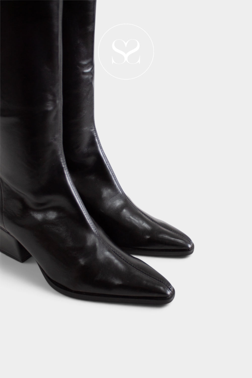 Black leather pointed-toe knee-high boots shown on a light gray background with a faint circular logo watermark near the top center.