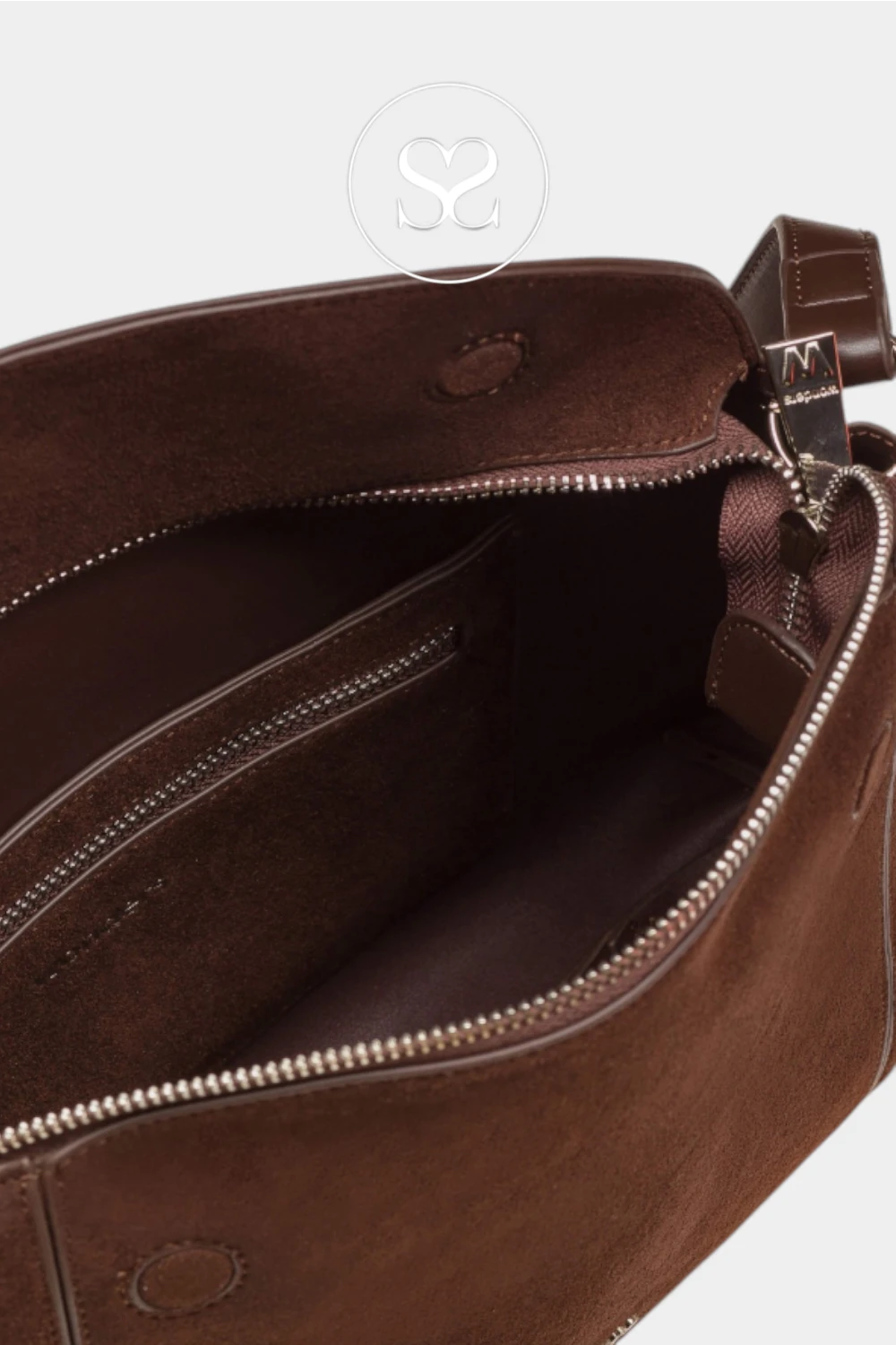 Close-up of the interior of a brown leather bag, showing a zippered compartment, interior pocket, and metal zipper pulls on a light gray background.