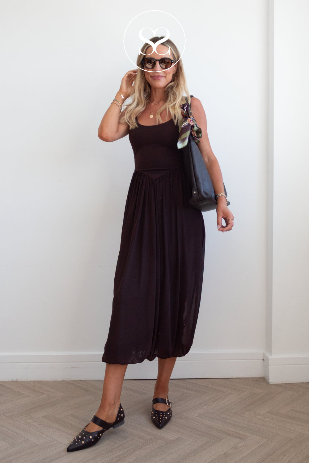 Woman in chocolate brown leather pointed toe ballet flats - dressy, paired with dark brown leather shopper and sunglasses