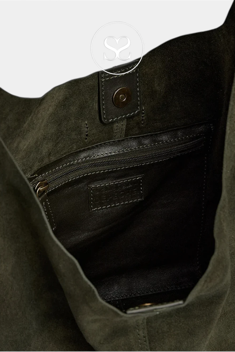 Close-up of the interior of a dark olive green suede or faux-suede tote bag, showing a black zippered pocket with a leather label and a metal snap tab.