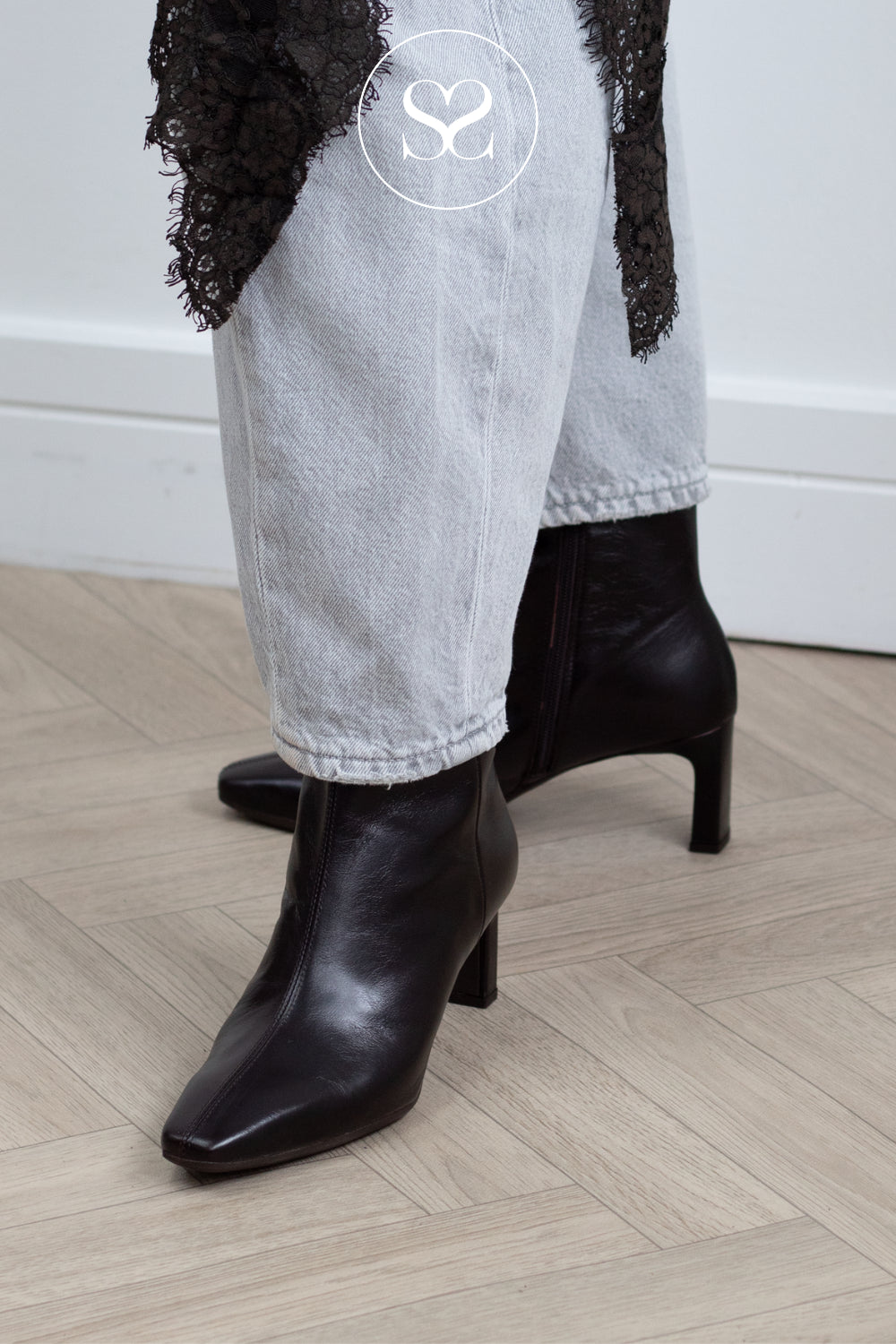 Woman wearing Wonders Chocolate Brown Pointed Heeled Ankle Boots with grey jeans and lace trim - from Sheneil Shoes in Ireland